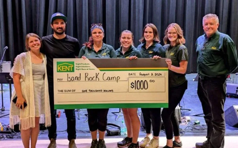 KENT associates proudly displaying a check for $5,000 for charity camp, celebrating their achievement together